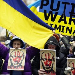 Demonstrations showing Ukraine flag and Putin portraite with Red bloodied hand print on his face.