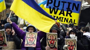 Demonstrations showing Ukraine flag and Putin portraite with Red bloodied hand print on his face.